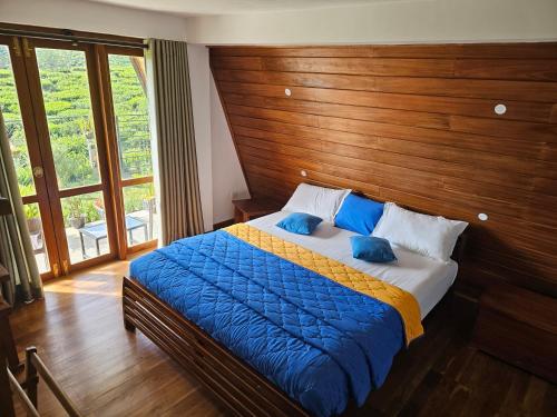 a bedroom with a large bed with a wooden headboard at Green Valley Cabin Nuwara Eliya in Nuwara Eliya
