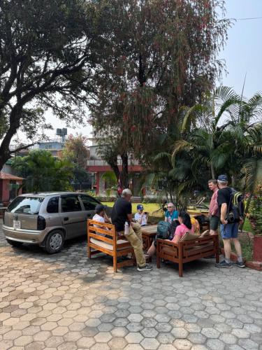 a group of people sitting on benches in a park at Butterfly Lodge in Pokhara