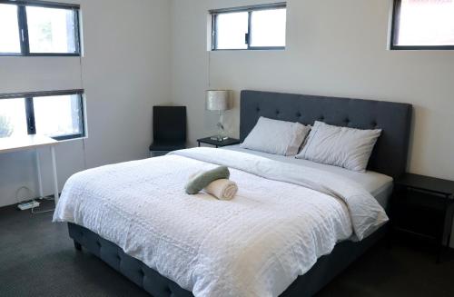 a bedroom with a large bed with a stuffed animal on it at Home Sweet Perth in Perth