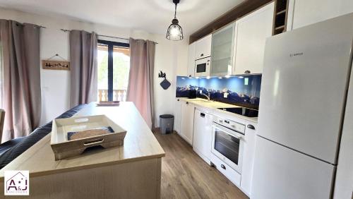 a kitchen with a white refrigerator and a counter top at L'Etoile du Berger Chalet des Etoiles 8 pers in Bagnères-de-Bigorre