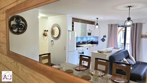a kitchen and a dining room with a table and chairs at L'Etoile du Berger Chalet des Etoiles 8 pers in Bagnères-de-Bigorre