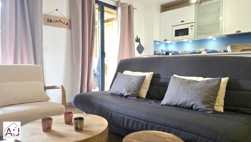 a living room with a couch and a chair at L'Etoile du Berger Chalet des Etoiles 8 pers in Bagnères-de-Bigorre