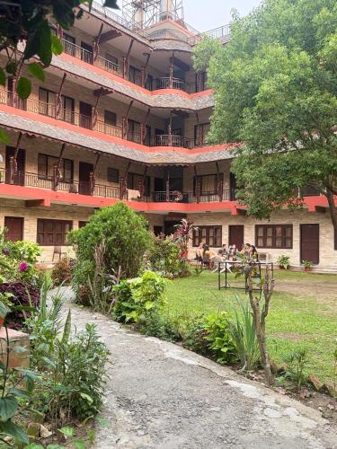 a large building with people sitting in front of it at Butterfly Lodge in Pokhara