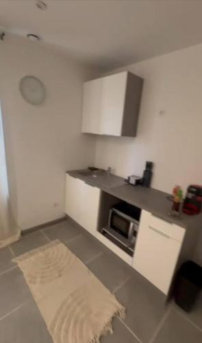 une petite cuisine avec un comptoir et un micro-ondes dans l'établissement Appartement centre ville Béziers, à Béziers