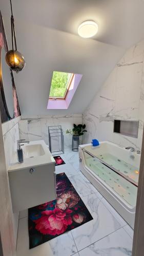 a bathroom with a tub and a sink at Domek Liliowe Marzenie in Chrzanów