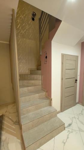 a stairway in a room with a wall and a door at Domek Liliowe Marzenie in Chrzanów