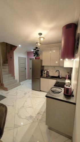 a kitchen with white cabinets and a counter top at Domek Liliowe Marzenie in Chrzanów