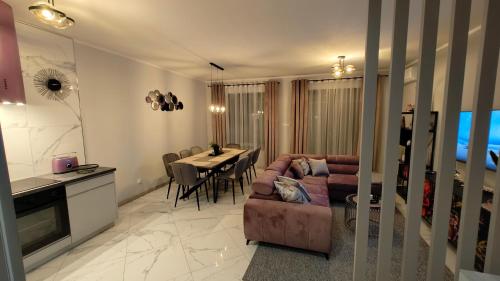 a living room with a couch and a table at Domek Liliowe Marzenie in Chrzanów