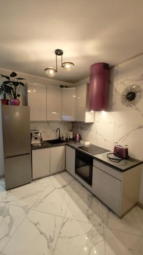 a kitchen with white cabinets and a red appliance at Domek Liliowe Marzenie in Chrzanów