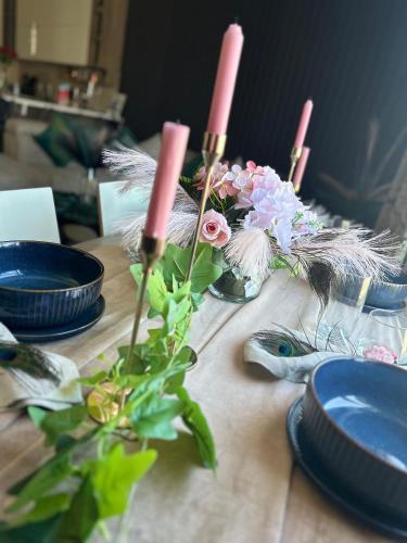 a table with blue plates and pink candles and flowers at Couple's Getaway in Is-Swieqi