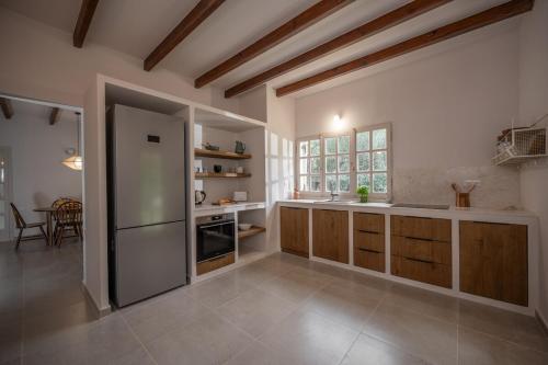 eine große Küche mit Holzschränken und einem Kühlschrank in der Unterkunft Anoixi vacation home with spectacular Evia landscapes in Loukísia