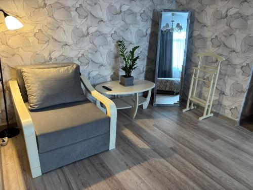 a living room with a chair and a table at Квартира в Вышгороде для души in Vyshhorod