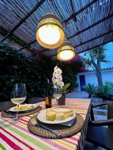 a table with a plate of bread and wine glasses at Casa do Rei Aroeira in Charneca