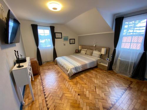 a bedroom with a bed and a television in it at Casa do Rei Aroeira in Charneca