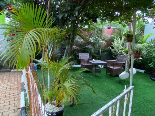 a garden with palm trees and chairs and a fence at Green Enchantment Home in Nalakonge