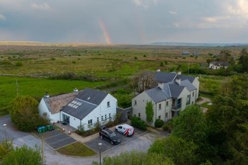 an aerial view of a house with a rainbow in the background at Burren Court Lodge in Ballyvaughan