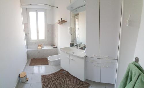 une salle de bain blanche avec un lavabo et des toilettes dans l'établissement Spacieux T3 proche gare St-Charles - Vieux Port, à Marseille