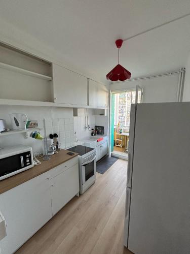  La cuisine est équipée de placards blancs et d'un réfrigérateur. dans l'établissement Spacieux T3 proche gare St-Charles - Vieux Port, à Marseille