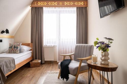 a bedroom with a bed and a table with a chair at U Dzikosa in Ząb
