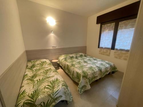 a bedroom with two beds and a window at Villa Gloria appartamento D01 in Rosolina Mare
