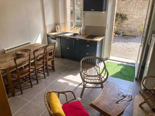 une cuisine et une salle à manger avec une table et des chaises dans l'établissement Gîte l'Ancienne Lieutenance à 200m de la plage - Veules-les-Roses, à Veules-les-Roses