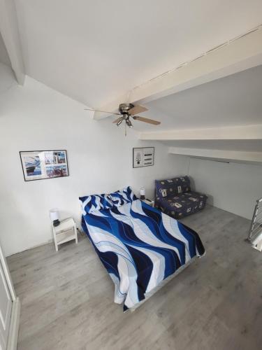 une chambre avec un lit et un ventilateur de plafond dans l'établissement appartement avec vue sur l étang de Barcares, au Barcarès