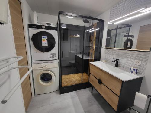 une salle de bain avec une machine à laver et un lavabo dans l'établissement appartement avec vue sur l étang de Barcares, au Barcarès