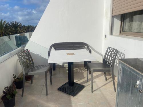 a white table and two chairs on a balcony at Beaulieu du Park commode et paisible in Mohammedia