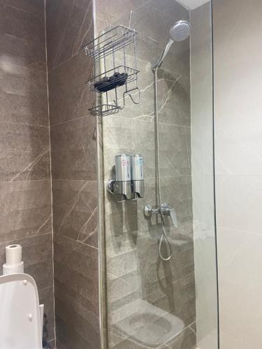 a shower with a glass door in a bathroom at Beaulieu du Park commode et paisible in Mohammedia