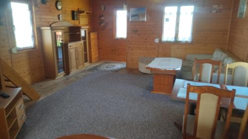 a living room with a couch and a table at Domki Orla na Mazurach in Pasym