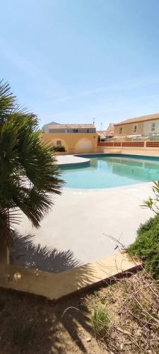 une piscine devant un immeuble dans l'établissement Villa Mimosa Côté Mer et Piscine, à Frontignan