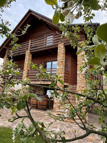 a log cabin with flowers in front of it at Siedlisko na Winnicy in Opatów