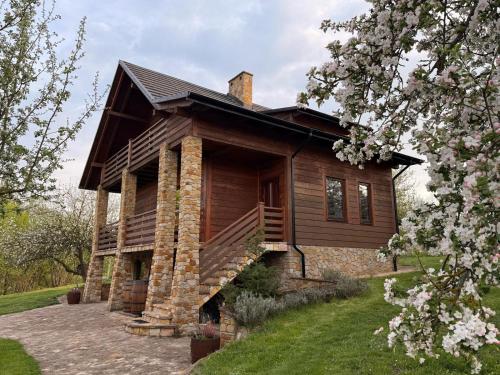 a log cabin with a porch and a chimney at Siedlisko na Winnicy in Opatów