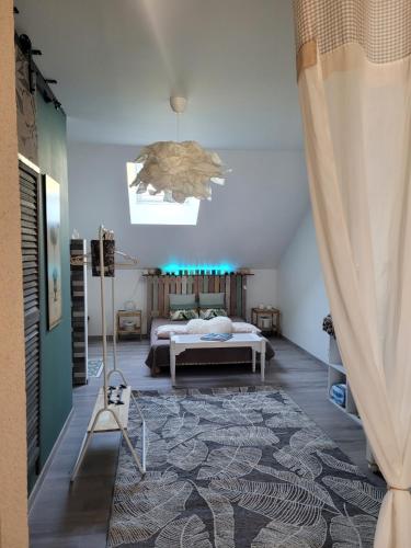 une chambre avec un lit et un lustre dans l'établissement La CASITA, à Bléré