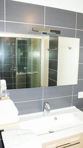 une salle de bain avec un lavabo et un miroir dans l'établissement Gite de Leoli Ardèche, à Saint-Remèze