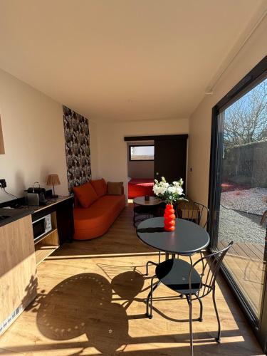 un salon avec une table et un canapé dans l'établissement Maison cosy proche Rennes, à La Mézière
