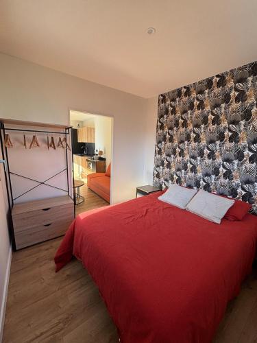 une chambre avec un lit rouge et un miroir dans l'établissement Maison cosy proche Rennes, à La Mézière