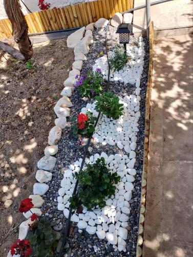 a garden with rocks and flowers in a yard at White lilies the house of gourmet flavours in Chios