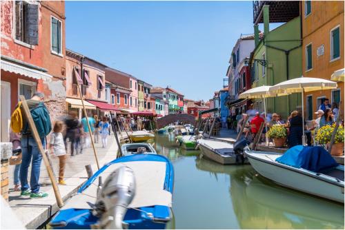 a boat is docked on a canal in a city at Tiffany Silver in Burano