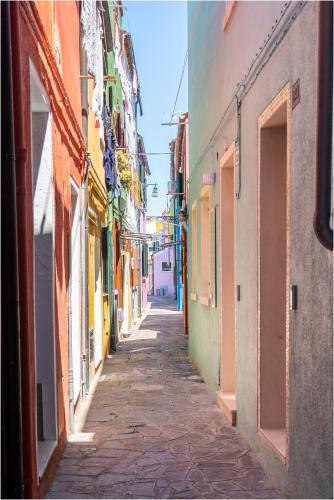 an alley way between buildings in a city at Tiffany Silver in Burano