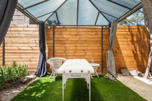 a greenhouse with a table and chairs in the grass at Villa Rasoa in Cap d'Agde
