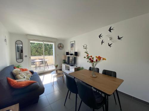 un salon avec une table et un canapé bleu dans l'établissement La Plage, à La Londe-les-Maures