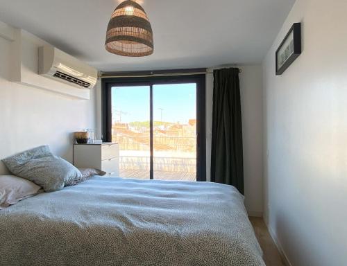 une chambre avec un lit et une grande fenêtre dans l'établissement Rooftop en centre ville, à Bayonne