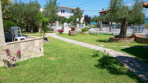 a lawn with a white chair in a yard at Villa Alexandra Suites in Polychrono
