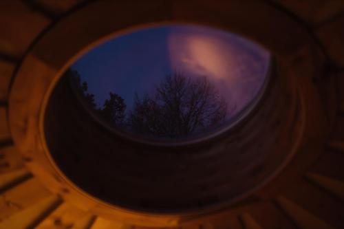 a round window with a tree in the sky at Glamp V Hluboké - Yurts and Wooden Houses in Vsetín