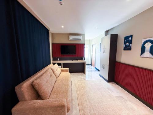 Una sala de estar con un sofá y un televisor. en Sky Luxe Hotel Konyaaltı, en Antalya