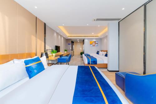 a hotel room with a large bed and blue chairs at Weekend International Apartment- Beijing Rd A-mall in Guangzhou