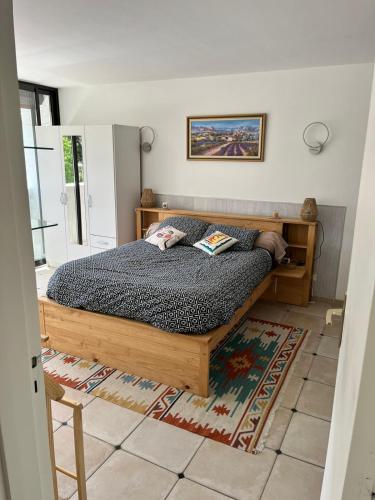 une chambre avec un lit en bois dans une pièce dans l'établissement Le Gryselis, à Gréoux-les-Bains