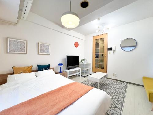 a bedroom with a white bed and a television at Stylish ROCO house Omori8min in Tokyo