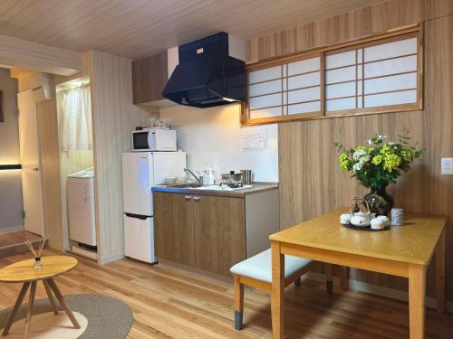 a small kitchen with a table and a refrigerator at TOKYO SKYTREE VILLIA-Whole villia space perfect for families and groups in Tokyo